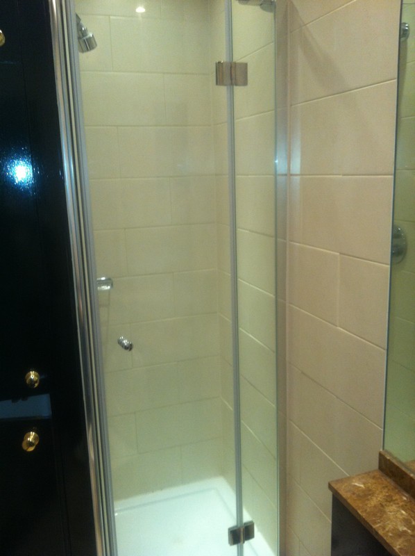 Frameless glass shower enclosure with chrome fittings in South Norwood