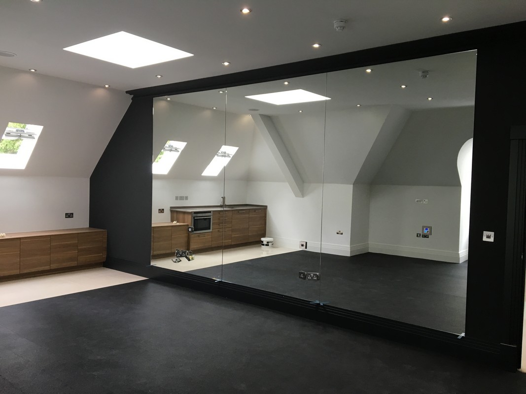 Frameless glass wall dividing loft conversion in South Norwood